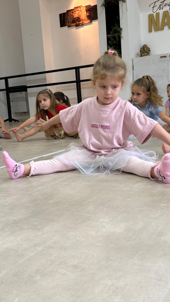 Niña elongando en clase de danza